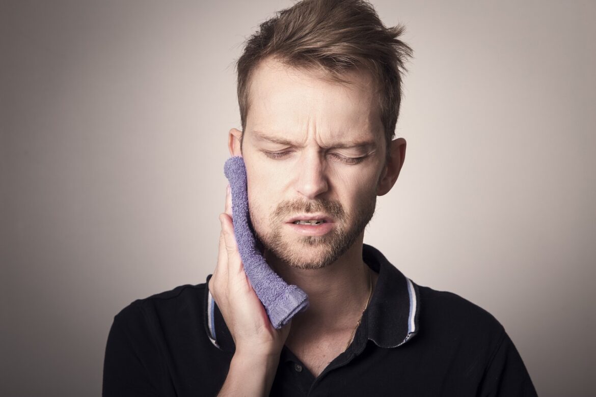 man with jaw pain and a cloth on face