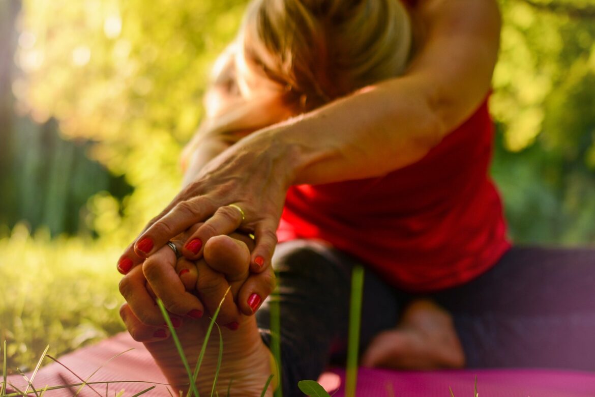 woman stretching with fingers interlocked into toes